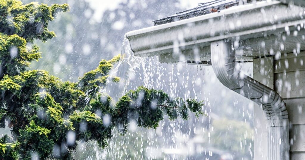 water pouring over flooded gutters during a heavy rain storm