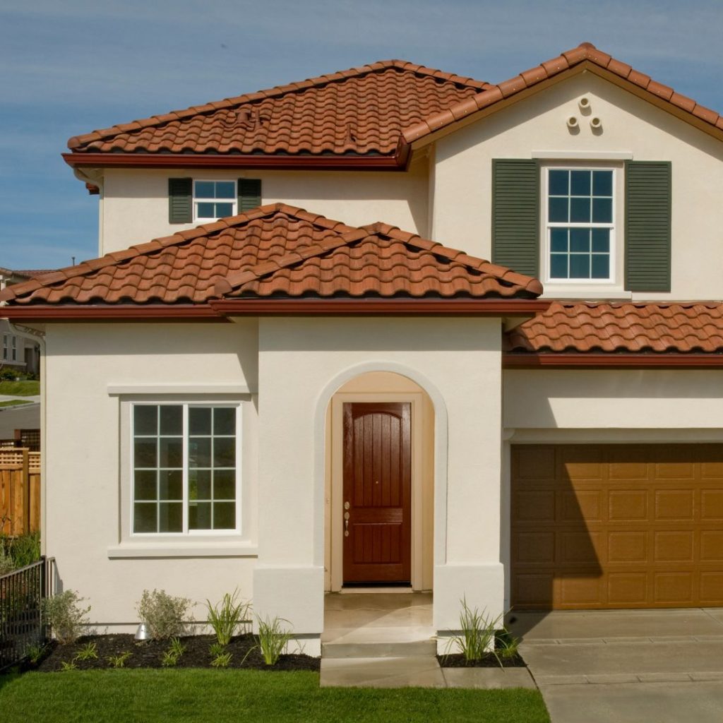 beige stucco house with red clay tile roofing material
