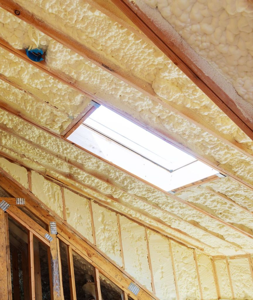 unfinished attic with light yellow spray foam roof insulation