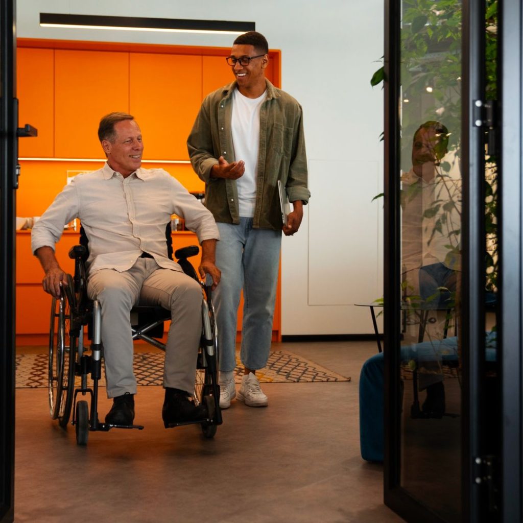 man in wheelchair with friend is home with wheelchair accessibility